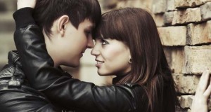 Happy young couple in love at the brick wall