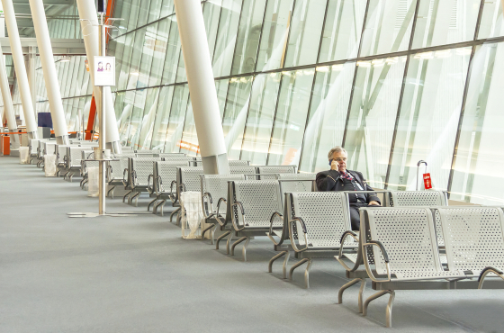 Airport business man with smart phone is waiting in terminal for