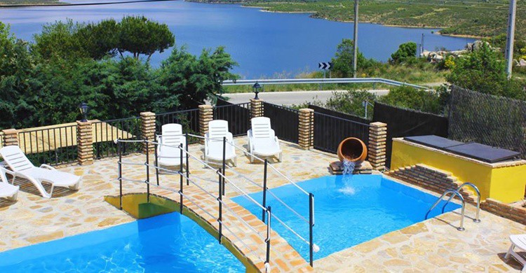 En primer término la piscina, y de fondo, el embalse. (www.facebook.com/Estudios-Finca-El-Destino)