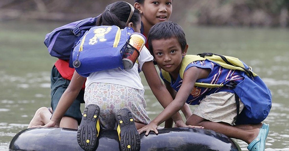 Niños atravesando un río en Rizal, Filipinas (Fuente: EPA)