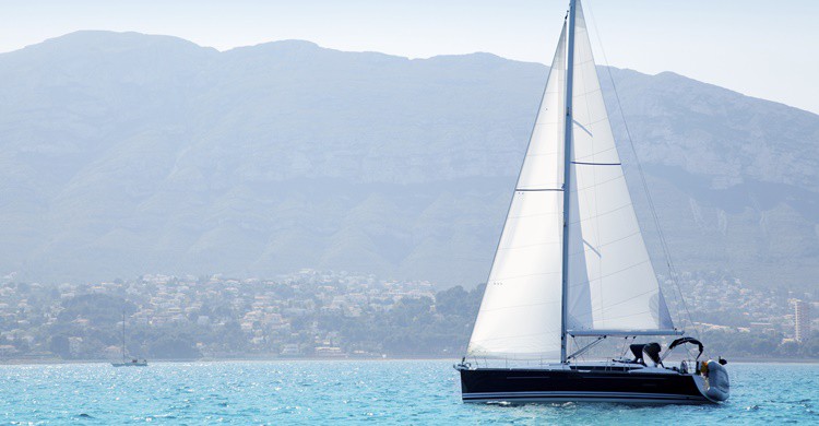 Barco navegando en la costa de Denia. LUNAMARINA (iStock)