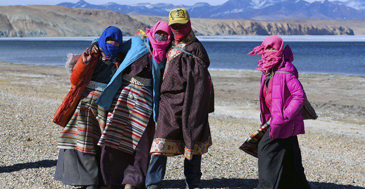 Peregrinos tibetanos junto a uno de los lagos del monte Kailash. Zzvet (iStock)