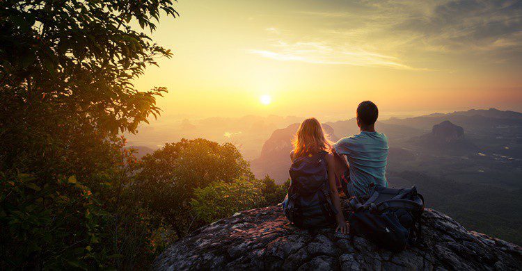 Pareja viendo una puesta de sol en la naturaleza. Mihtiander (iStock)