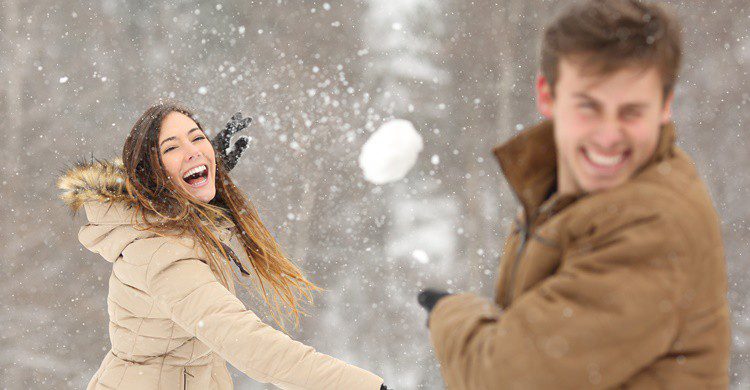 Pareja jugando en la nieve. AntonioGuillem (iStock)