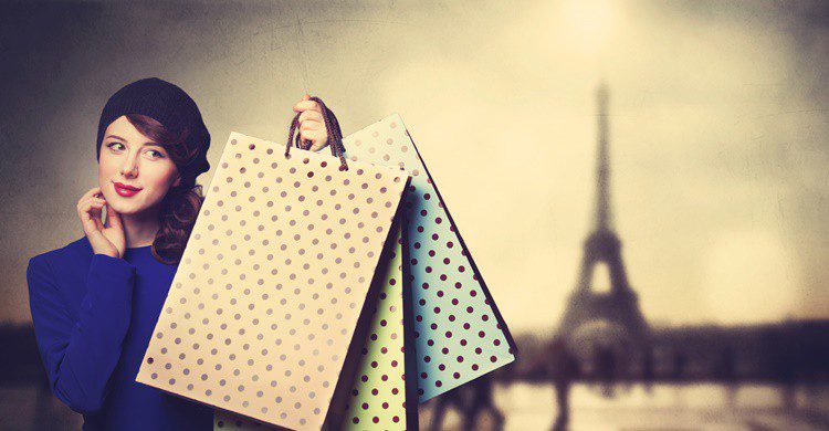 Mujer con bolsas frente a la Torre Eiffel. Massonstock (iStock)