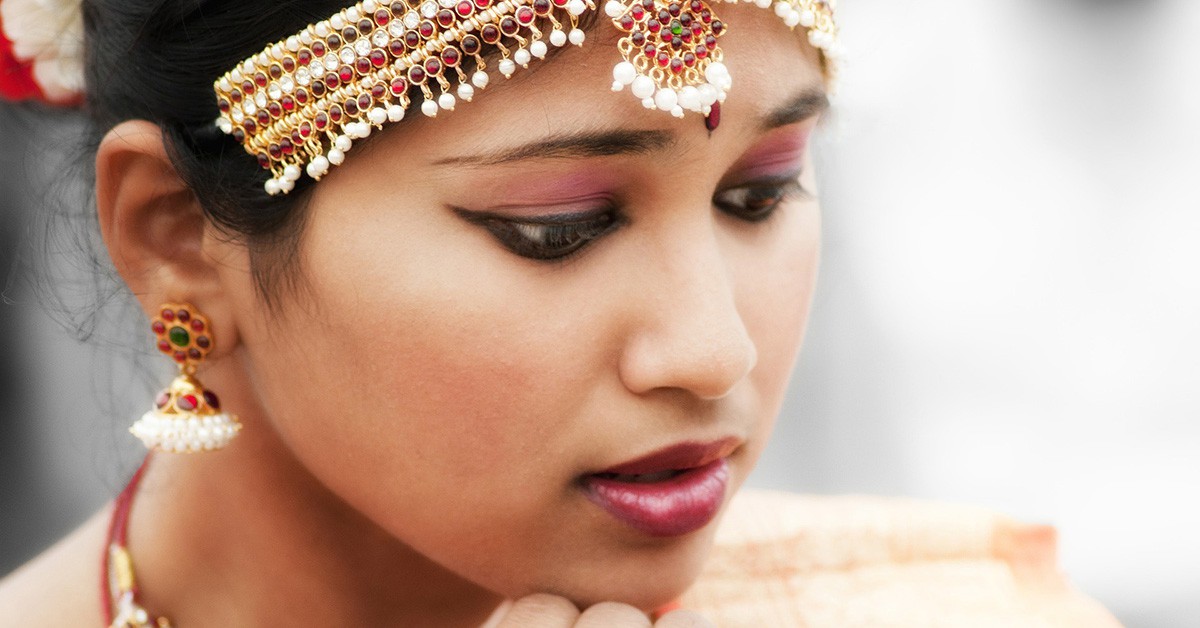 Una mujer de la India con el pelo recogido y los complementos típicos de su cultura