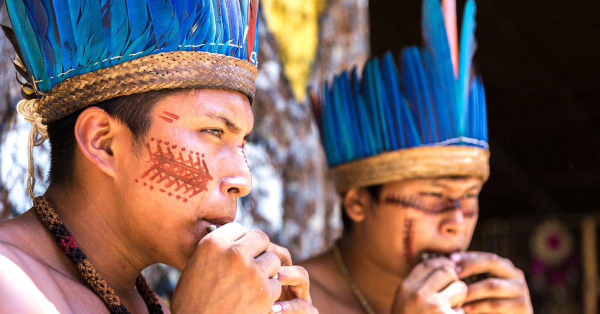 Dos miembros de una tribu tocan un instrumento en la Amazonía brasileña