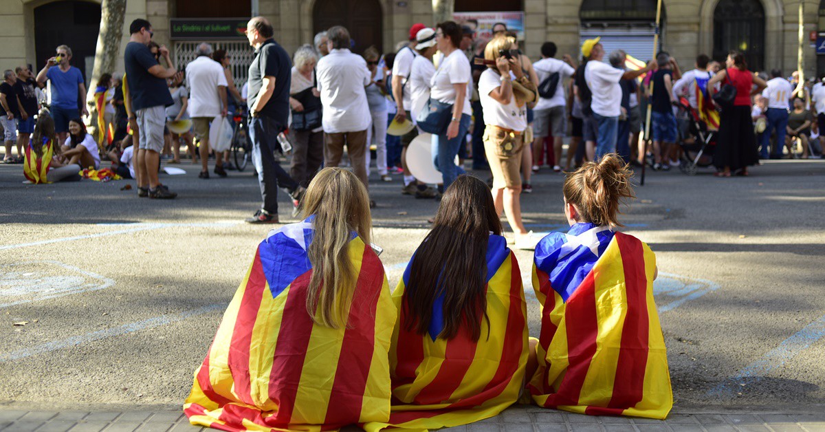Imagen de tres chicas con banderas independentistas durante una manifestación.