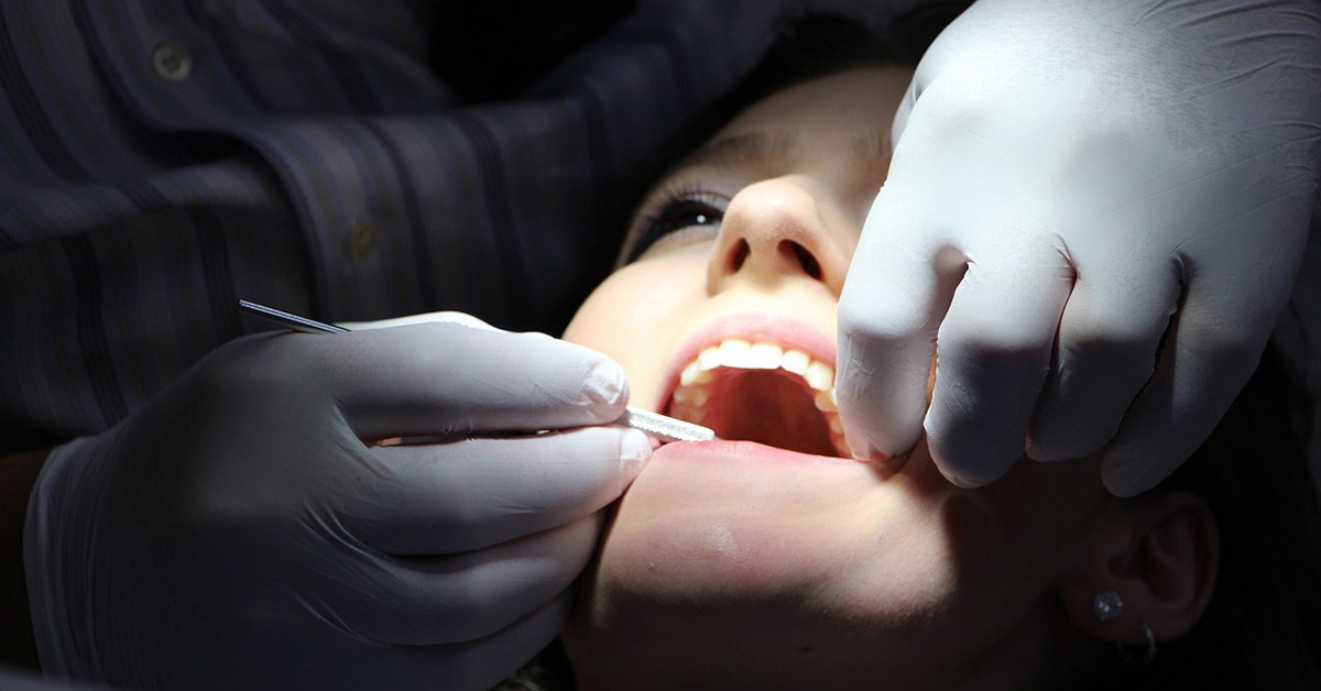 Dentista realizando una limpieza dental en una paciente