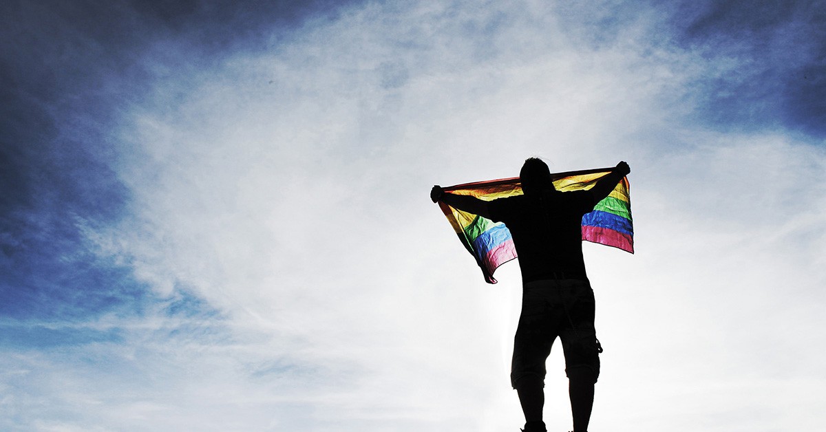 Un hombre sostiene una bandera LGBT