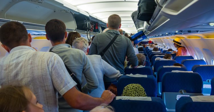 Imagen de unos pasajeros colocando las maletas en un avión.