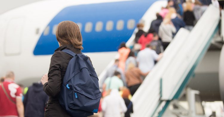 Imagen de pasajeros embarcando en un avión a punto de despegar. 