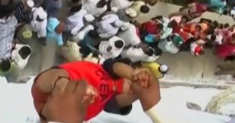 Imagen de un indio lanzando un bebé desde una terraza.