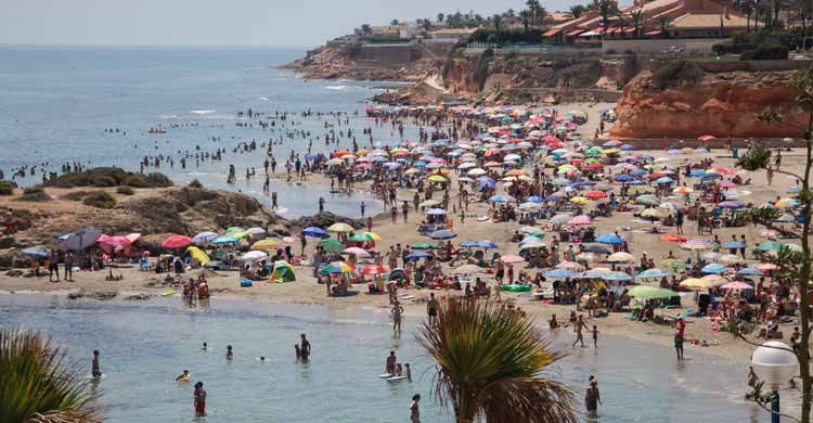playa llena de bajistas y turistas