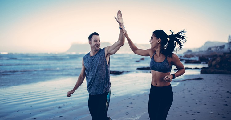 Una pareja corre en una playa