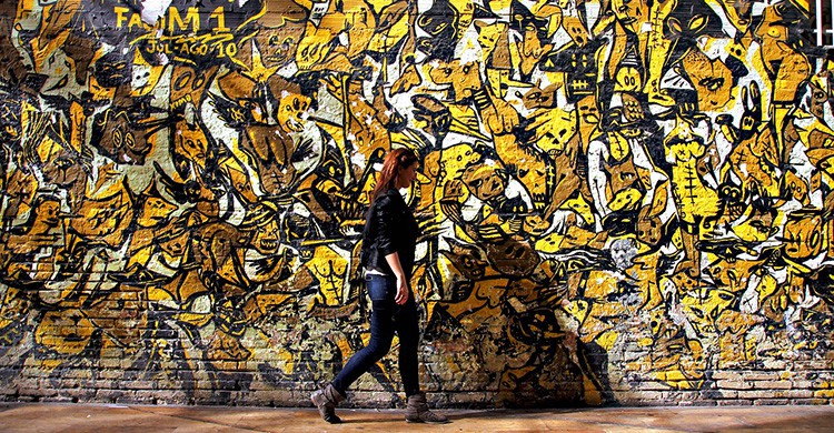 Una mujer pasa delante de un graffiti