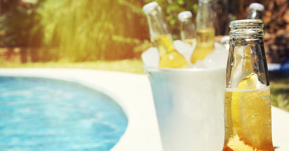Botellas de cerveza al borde de una piscina