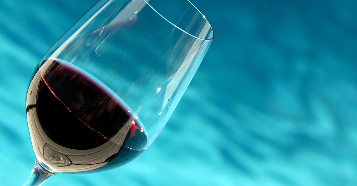 Copa de vino tinto en la piscina