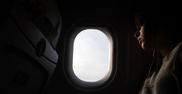 Una persona mira por la ventanilla del avión