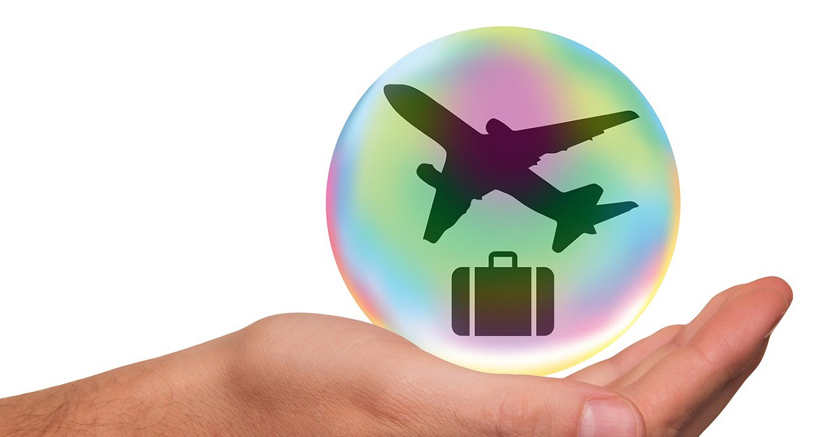 Imagen de un avión con maleta sobre una mano abierta