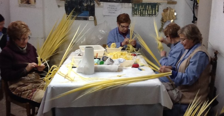 Mujeres llamadas rizadoras preparan la palma blanca