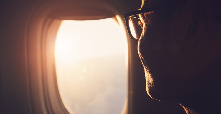 Una persona al lado de la ventanilla de un avión