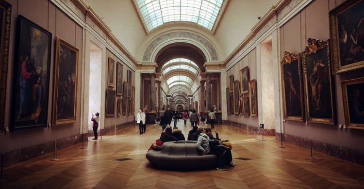 Personas sentadas en el interior de un museo 