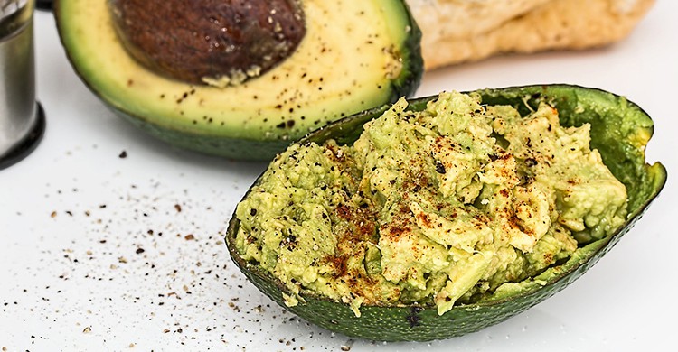 Porción de guacamole servida en la cáscara de un aguacate