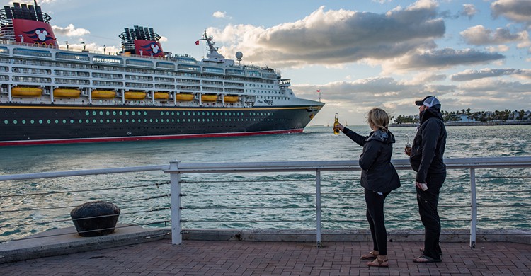 Dos personas saludan un crucero