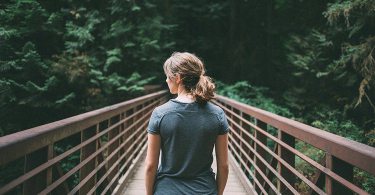 Una mujer en un puente en plena naturaleza