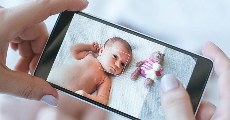 Una madre hace una foto de su bebé con el móvil
