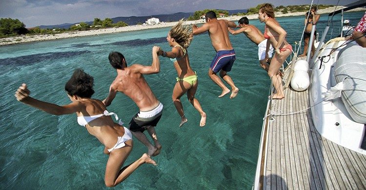 Grupo de amigos disfrutando de un velero en las aguas de Croacia (GlobeSailor).