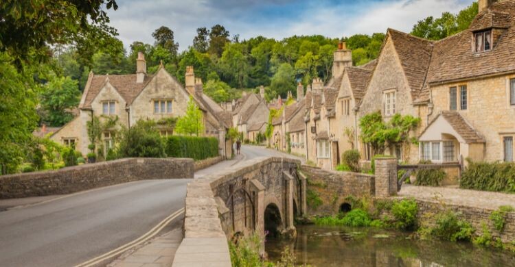Antiguas casas de campo tradicionales y una calle junto a un río en Castle Combe, en Cotswold, Inglaterra. (Adobe Stock)