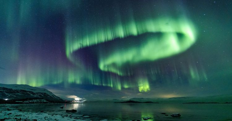Danza de auroras boreales sobre el lago Torneträsk, en Suecia. (Adobe Stock)