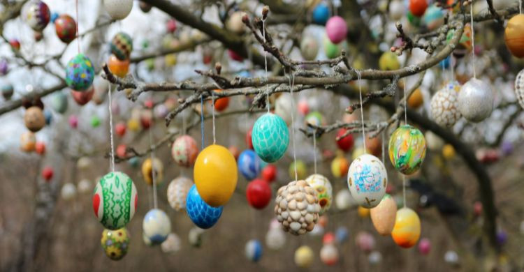 Huevos de Pascua coloridos colgados en las ramas de los árboles, en Alemania. (Adobe Stock)