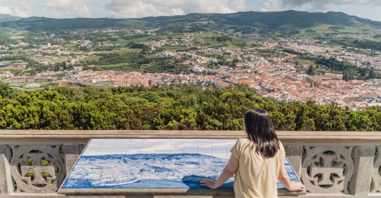 Mujer en el Monte Brasil contemplando las vistas a la ciudad de Angra do Heroísmo. (Adobe Stock)