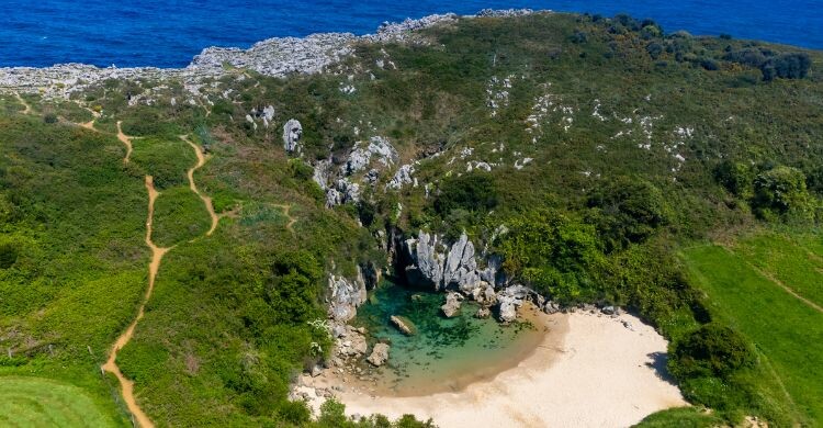 Vista aérea de la Playa de Gulpiyuri, sumidero inundado con playa interior cerca de Llanes, en Asturias, España. (Adobe Stock)