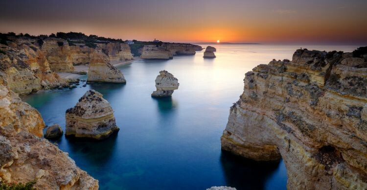 Puesta de sol cerca de la playa de Marinha, en la capital de Algarve, en Faro. (Adobe Stock)