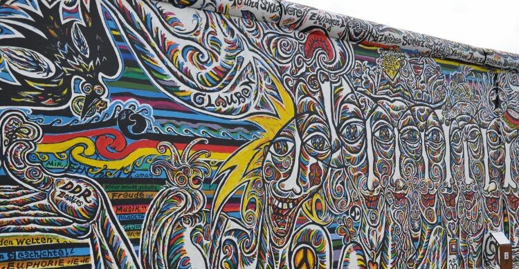 Este es alguno de los graffitis que puedes encontrar en el Muro de Berlín (Canva)
